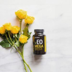 doTERRA vEO Mega Omega Komplex Kapseln neben gelben Rosen